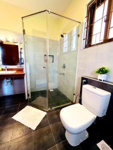 a bathroom with a toilet and a glass shower at Spacious three bedroom apartment with a pool in Mombasa