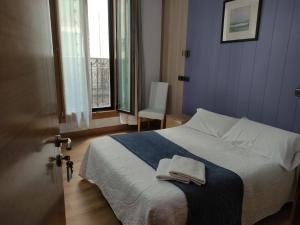 ein Schlafzimmer mit einem Bett mit zwei Handtüchern darauf in der Unterkunft AlojaDonosti City Center in San Sebastián