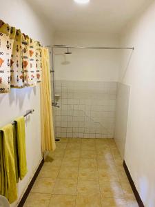 a bathroom with a shower and yellow towels at Fig Tree Lodge Camp in Mto wa Mbu