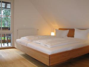 a large bed in a room with a window at Pension Tannenheim in Schluchsee