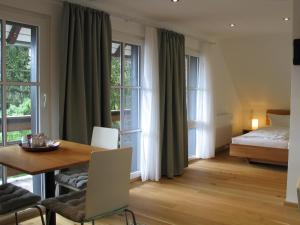 シュルッフゼーにあるPension Tannenheimのテーブルとベッドが備わる客室で、窓があります。