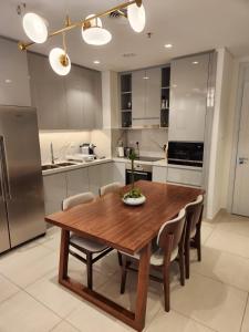 uma cozinha com uma mesa de jantar em madeira e cadeiras em Address Beach Resort Fujairah - 2 bedroom apartment em Fujairah