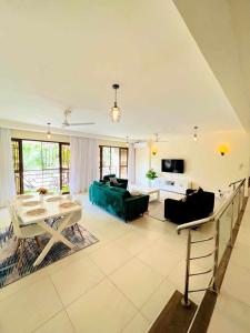 a living room with a green couch and a table at Spacious three bedroom apartment with a pool in Mombasa