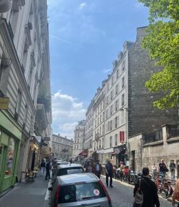 a street with cars parked on the side of a city at Charmant appartement sacré cœur avec parking gratuit in Paris