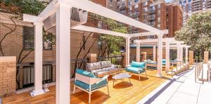 a pergola on a balcony with chairs and tables at Elegant and Charming Condo at Ballston with Pool in Arlington