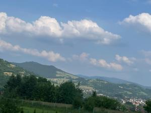 een uitzicht op een vallei met bergen en wolken bij Lawendowy apartament in Mszana Dolna