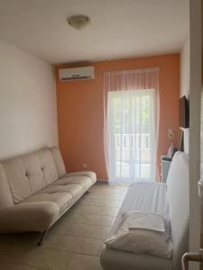 a living room with a couch and a window at Guesthouse Villa Jurišić in Novalja