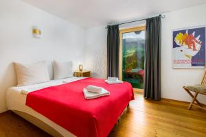 a bedroom with a red bed with a red blanket at Chalet Mora-lodge by Alpine Host Helpers in Kitzbühel