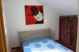 Un dormitorio con una cama y un cuadro en la pared. en Maison La Rascasse, en Rayol-Canadel-sur-Mer