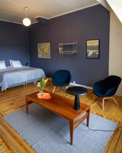 1 Schlafzimmer mit einem Bett, 2 Stühlen und einem Tisch in der Unterkunft Nordic Refuge B&B in Fröskog
