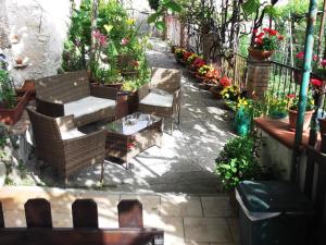 a patio with chairs and a table and flowers at Le Mimose in Vietri sul Mare