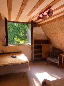 um pequeno quarto com uma cama e uma janela em Glampspace - Wikingówka em Międzybrodzie Bialskie