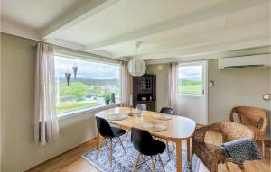 ein Esszimmer mit einem Tisch, Stühlen und einem Fenster in der Unterkunft Beautiful Home In Sveio With Wifi in Kvalvåg