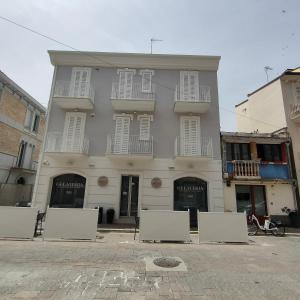 un gran edificio blanco con ventanas blancas en una calle en Casa vacanze la Rosa dei Venti, en Porto SantʼElpidio