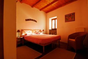 a bedroom with a bed and a chair and a window at Agriturismo Giandriale in Tavarone