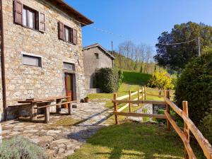 un edificio in pietra con una recinzione di legno accanto ad esso di Agriturismo Giandriale a Tavarone