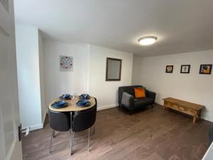 a living room with a table and a couch at The Crescent, Flat 1 - Stockport, Manchester in Manchester