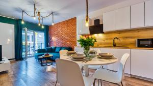 eine Küche und ein Wohnzimmer mit einem Tisch und Stühlen in der Unterkunft Apartament Malachit Osada Górska z prywatną sauną - 5D Apartamenty in Szklarska Poręba