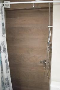 a shower with a wooden door with a shower curtain at Mina's Spacious Apt : June '23 Renovated in Thessaloniki