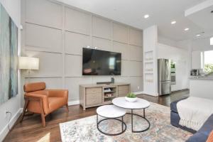 uma sala de estar com uma televisão, um sofá e uma mesa em Casa LaBella - Downtown Skyline Views - Sleeps 10 em Houston