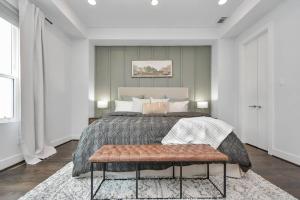 Un dormitorio con una cama grande y un banco en Casa LaBella - Downtown Skyline Views - Sleeps 10 en Houston