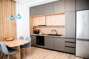 a kitchen with a table and a sink and a refrigerator at Magdalena Suite 3.0 in Heraklio