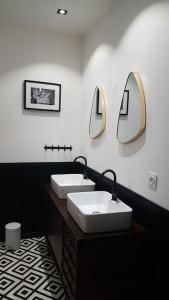 ein Badezimmer mit zwei Waschbecken und zwei Spiegeln an der Wand in der Unterkunft La villa du pressoir, classé 3 étoiles meublé de tourisme in Le Pallet