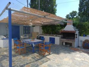 a patio with a table and chairs and a fireplace at ALMADOL HOUSE Chalkidiki Τρυπητή Χαλκιδικής in Nea Roda