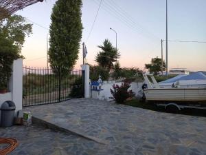 a house with a fence and a boat in a yard at ALMADOL HOUSE Chalkidiki Τρυπητή Χαλκιδικής in Nea Roda