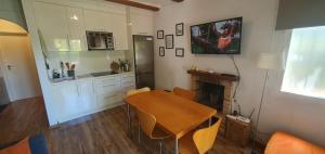 cocina con mesa de madera y chimenea en Bungalow Los Almendros, en Pedreguer