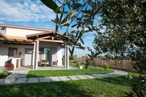 a house with a garden and a fence at Residence Pace & Relax in Marina di Grosseto