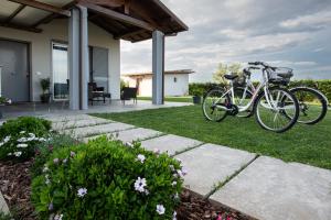 un vélo garé sur l'herbe à côté d'une maison dans l'établissement Residence Pace & Relax, à Marina di Grosseto