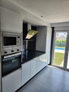 a kitchen with a stove and a microwave at villa requian in Cacheiras