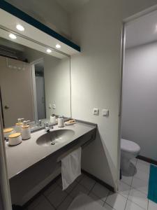 un bagno con lavandino, specchio e WC di Un petit joyau a Le Diamant