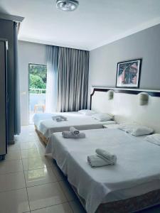 pokój hotelowy z 3 łóżkami i ręcznikami w obiekcie Infinity Hotel w mieście Kemer