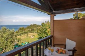 balcone con tavolo, bicchieri da vino e vista sull'oceano di Arpyia a Vasilikós