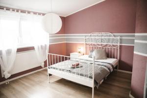 a childs bedroom with pink and gray stripes at Modernes Apartment mit Top Ausstattung und Kamin im Oberpfälzer Seenland in Nittenau