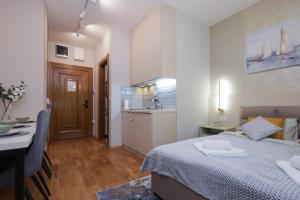 une chambre avec un lit et une table et une cuisine dans l'établissement ETA 2 APARTMENT, à Palić