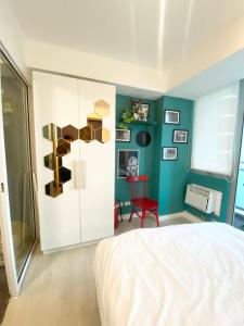 1 dormitorio con cama y pared azul en Marshall’s Place Azure Staycation, en Manila