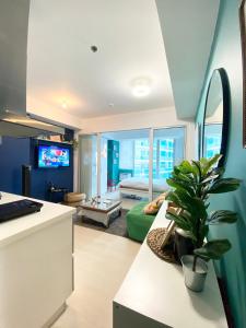 cocina y sala de estar con sofá verde en Marshall’s Place Azure Staycation, en Manila