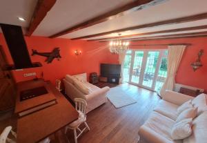 una sala de estar con paredes rojas y muebles blancos. en Barley View, en Aylmerton