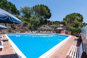 een groot zwembad met stoelen en parasols bij Casa Magnolia by Wonderful Italy in Aci Castello