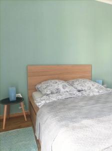 una camera con letto con testiera in legno e tavolo di City and Thermal Apartman a Győr