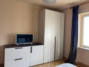 - une chambre avec une armoire blanche et un ordinateur dans l'établissement Civicocentouno, à Settimo Vittone