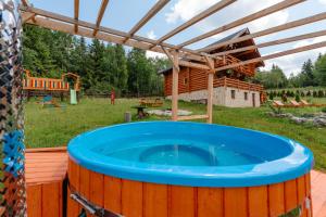 a hot tub in a backyard with a log cabin at Cabana Mirajul Apusenilor in Dealu Negru