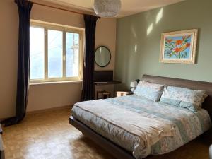 a bedroom with a large bed and a window at Civicocentouno in Settimo Vittone