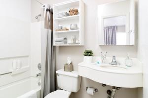 Baño blanco con lavabo y aseo en Intown Suites Extended Stay Charlotte NC - North Tryon, en Charlotte