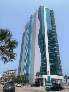 a tall building with cars parked in front of it at Highest Ocean Front View in Myrtle Beach