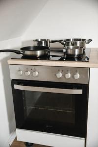 a stove with pots and pans on top of it at Modernes Apartment Schwarzenfeld in Schwarzenfeld