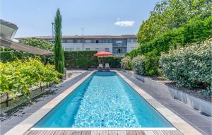波爾多的住宿－Nice Home In Bordeaux With Outdoor Swimming Pool，一个带遮阳伞的庭院内的游泳池